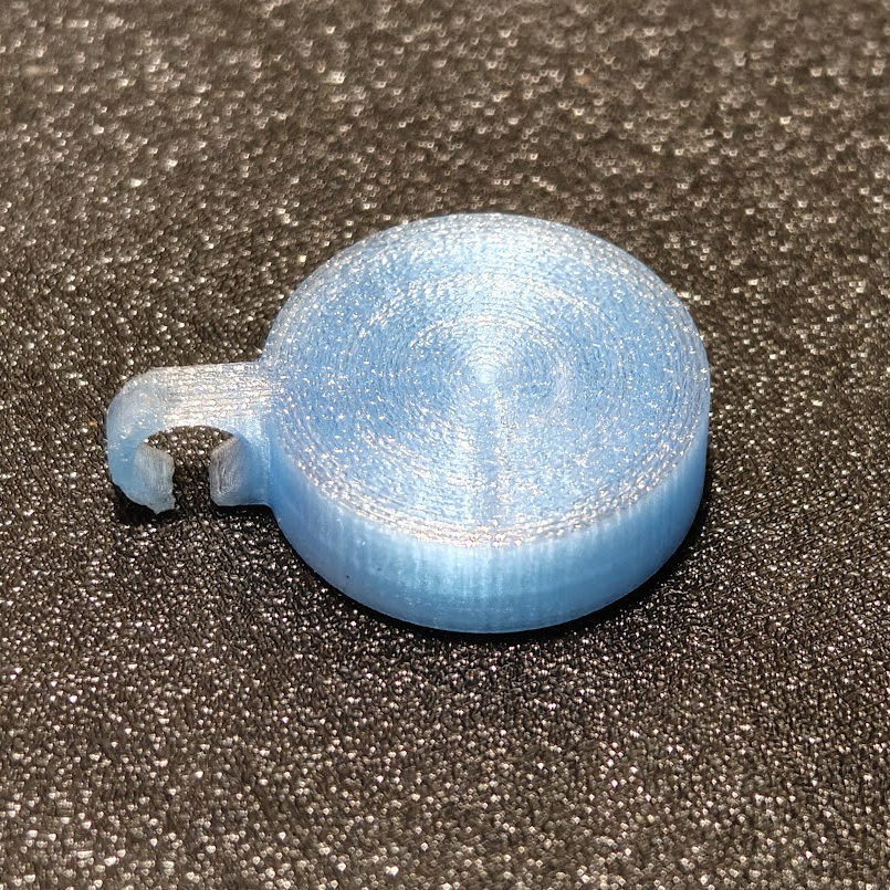 Blue 3D-printed object on a textured gray surface